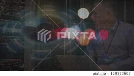 Image of blurred traffic lights over processing circle over caucasian man checking servers 129535602