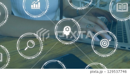 Image of falling education icons over person using laptop 129537746
