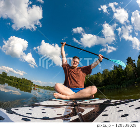 Man Taking Selfie on Paddleboard in Scenic Lake Man Taking Selfie on Paddleboard in Scenic Lake 129538029