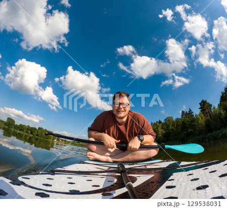 Man Taking Selfie on Paddleboard in Scenic Lake Man Taking Selfie on Paddleboard in Scenic Lake 129538031