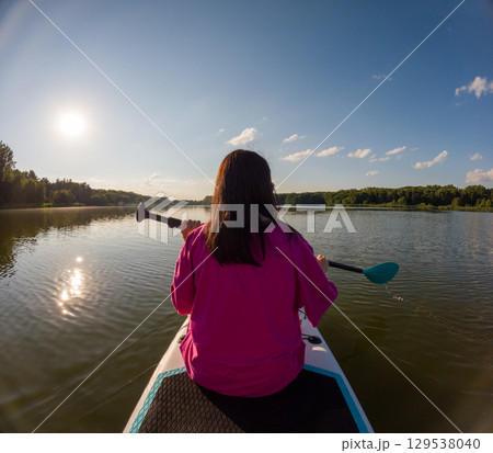 Paddleboarding on a Tranquil Lake Paddleboarding on a Tranquil Lake 129538040