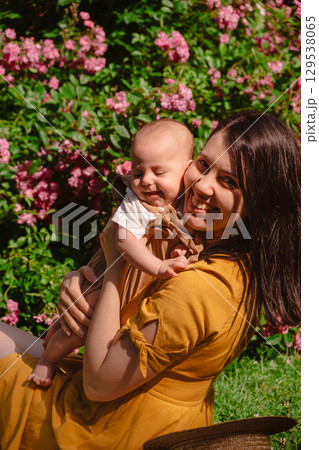 Joyful Mother and Baby in Blooming Garden Joyful Mother and Baby in Blooming Garden 129538065