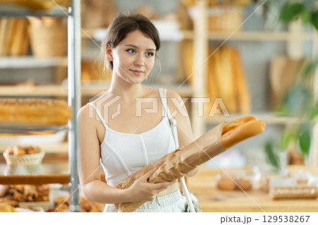 Young girl buys hot baguettes from private bakery 129538267