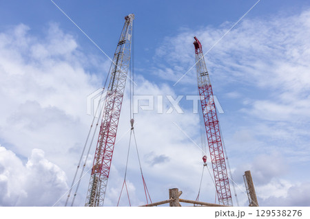 Crawler crane on blue sky white clouds background, Real estate industry. Red crawler crane use reel lift up equipment in construction site. Crane for rent. Crane dealership for construction business. Crawler crane on blue sky white clouds background, Real estate industry. Red crawler crane use reel lift up equipment in construction site. Crane for rent. Crane dealership for construction business. 129538276
