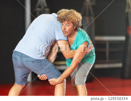 Middle aged man practicing close combat wrestling 129538354