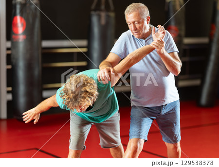Male pupil clash with training manager during self-defense lesson, repulse charge, intensity of practice 129538378