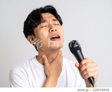 喉の調子が悪く歌いづらそうな男性 129538858