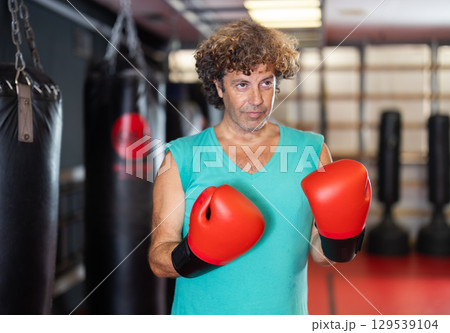 Man in red boxing gloves standing in gym 129539104