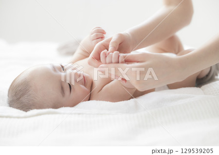 赤ちゃんのお世話をする若い母親 赤ちゃんのお世話をする若い母親 129539205