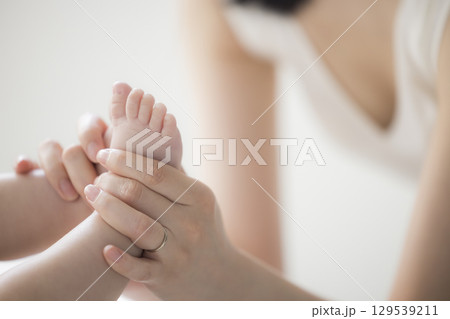 赤ちゃんのお世話をする若い母親 赤ちゃんのお世話をする若い母親 129539211