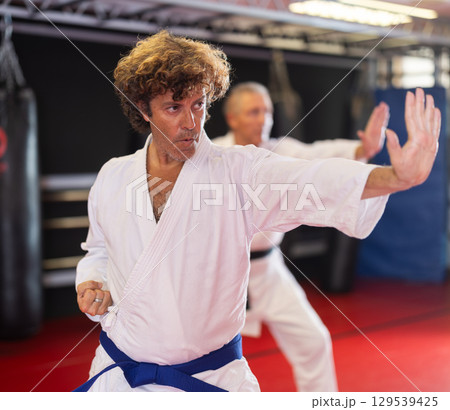 Karate student performing kata with instructor Karate student performing kata with instructor 129539425