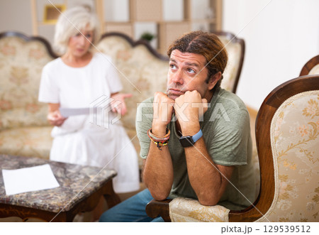 Mature couple fighting over documents, relationship problems Mature couple fighting over documents, relationship problems 129539512
