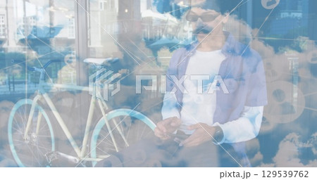 Image of network of connections and sky with clouds over african american man using smartphone 129539762