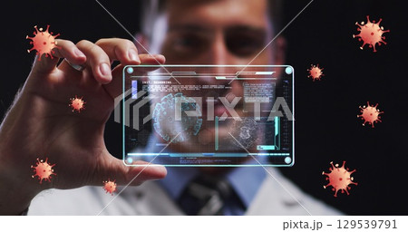Image of coronavirus cells over male doctor holding clear tablet processing data about cell Image of coronavirus cells over male doctor holding clear tablet processing data about cell 129539791