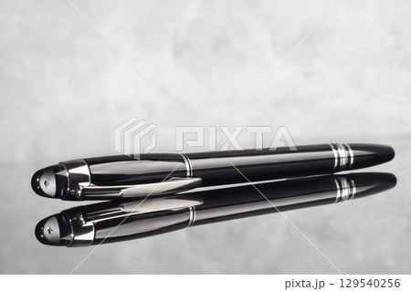 Branded fountain pen on marble gray background. Gift set. Office interior. 129540256