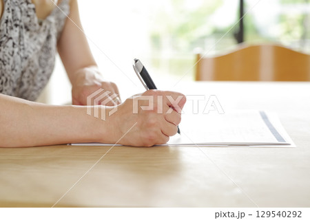 契約書に署名する女性の手元 契約書に署名する女性の手元 129540292