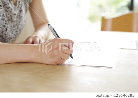 契約書に署名する女性の手元 契約書に署名する女性の手元 129540293