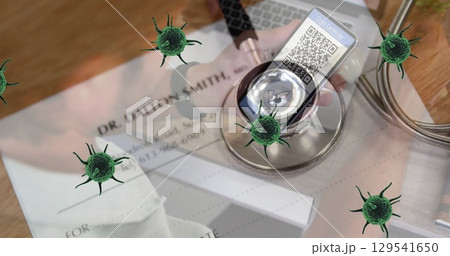 Image of green cells over stethoscope, documents and man with smartphone with covid passport 129541650