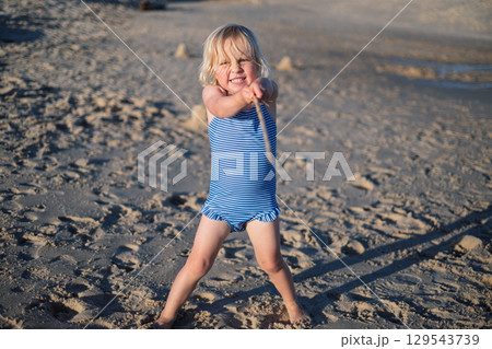 Girl Playing on the Beach During Vacation Girl Playing on the Beach During Vacation 129543739