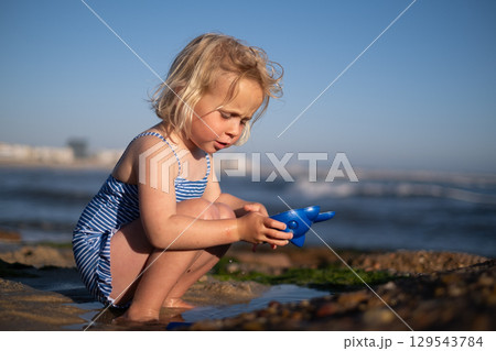 Girl Playing on the Beach During Vacation 129543784