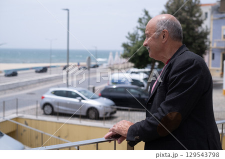 Elderly Spanish Man Walking in a Portuguese City and Looking at the Ocean. He Wears a Jacket and Has a Mustache 129543798