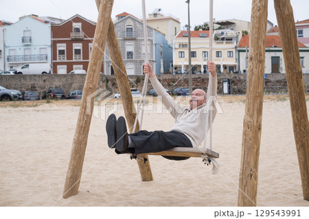 An elderly person swinging on a swing, reminiscing about childhood. 129543991