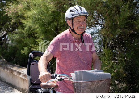 Elderly Man with Mustache and Helmet Riding a Bicycle 129544012