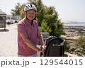 Elderly Man with Mustache and Helmet Riding a Bicycle 129544015