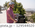 Elderly Man with Mustache and Helmet Riding a Bicycle 129544020