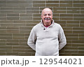 Elderly Spanish Man Standing by a Wall and Smiling 129544021
