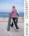Elderly Man Exercising on Outdoor Gym Equipment and Looking at the Ocean. Healthy Lifestyle 129544057