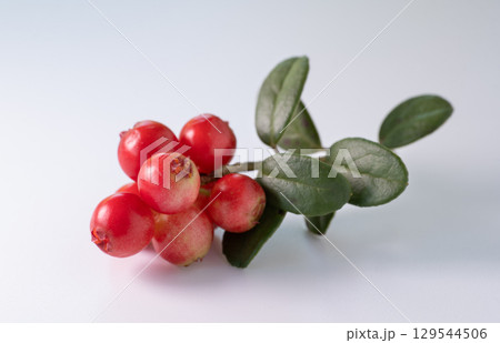 Red ripe lingonberry (cowberry) with leaves on white background. Red ripe lingonberry (cowberry) with leaves on white background. 129544506