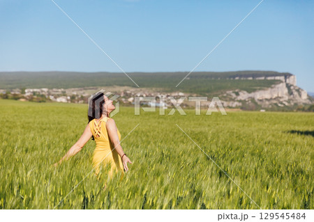 woman in a yellow dress in a field of wheat woman in a yellow dress in a field of wheat 129545484