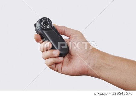 man using a battery-powered fan to refresh himself 129545576