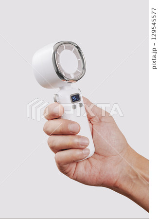 close-up of a man cooling himself with a white fan close-up of a man cooling himself with a white fan 129545577