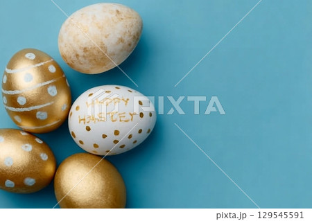 Easter background. Easter golden decorated eggs on blue background. Minimal easter concept. Flat Lay of Golden Easter Eggs 129545591