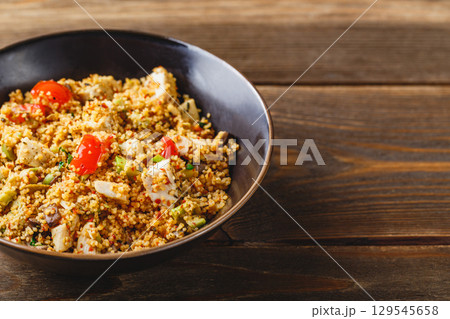 Couscous with turkey, tomatoes, champignon mushrooms and avocado. 129545658