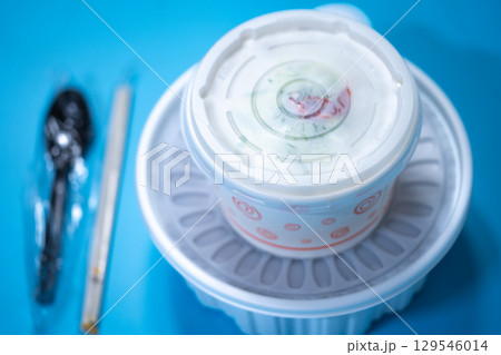 Kalguksu in a plastic box on a blue background. Food delivery 129546014