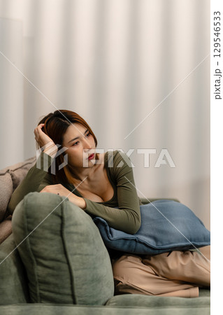 Woman sitting in sofa holding pills, having stress, boredom, loneliness, anxiety. Woman sitting in sofa holding pills, having stress, boredom, loneliness, anxiety. 129546533