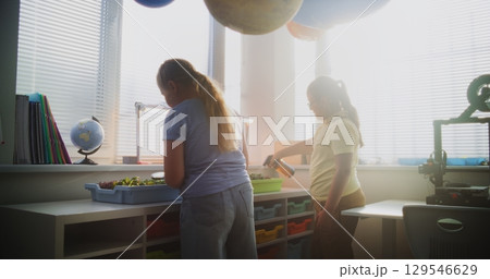 Smart Young Girls Growing Experimental Microgreens, Studying Biology and Botany in Classroom 129546629