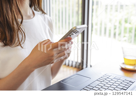 スマートフォンを操作する笑顔の女性 129547141