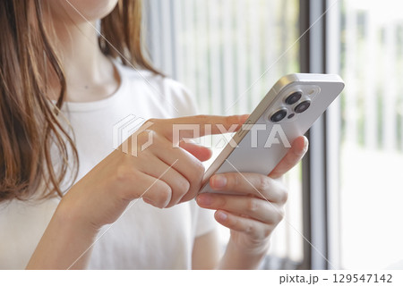 スマートフォンを操作する女性 129547142