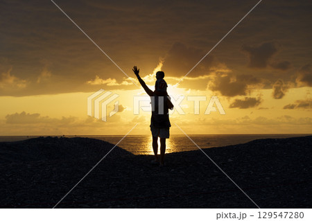 Father and Son Silhouettes at Sunset. Family Bonding Moment 129547280