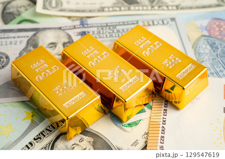 Gold bars on US dollar banknote money, finance trading investment business currency. Gold bars on US dollar banknote money, finance trading investment business currency. 129547619