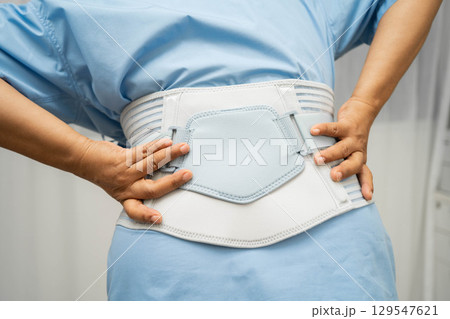 Asian senior pain back wearing elastic support belt with walker. Asian senior pain back wearing elastic support belt with walker. 129547621