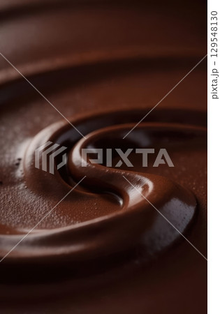Melted milk chocolate swirling in a perfect brown spiral 129548130