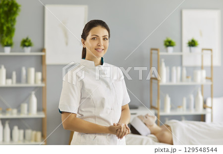 Cosmetologist and professional beautician before spa beauty treatment and therapy for female client 129548544