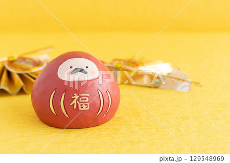 黄色い背景に縁起物の開運ダルマ　可愛い和風の年賀状 129548969