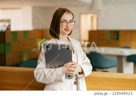A Confident Young Professional in a Modern Office, Exuding Style and Determination A Confident Young Professional in a Modern Office, Exuding Style and Determination 129549523