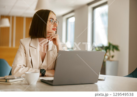 A Professional Woman in a Modern Office Environment Reflecting on Her Work and Future A Professional Woman in a Modern Office Environment Reflecting on Her Work and Future 129549538